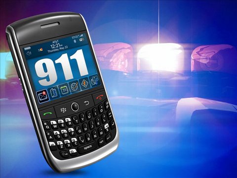 Cellphone with 911 onscreen and police siren backdrop