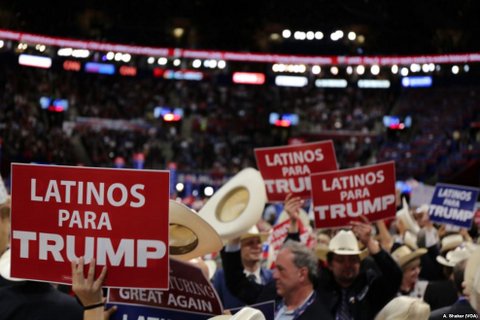 People hold signs that read "Latinos para Trump" at the 2016 Republican National Convention.