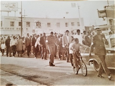 Sepia-toned photo of several Black people walking on a Richmond street in protest.