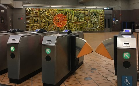 Fare gates and mural at a BART station