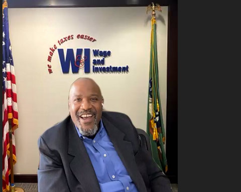 Smiling Black man with the words "Wage and Investment. We make taxes easier" on wall behind him.