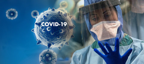 Image of coronavirus cells, one with the words COVID-19 on it, next to a medical worker in full protective gear looking at her gloved hand.