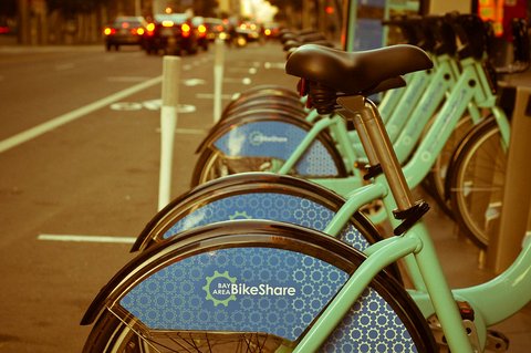 A row of light green Bay Area Bikeshare bicycles