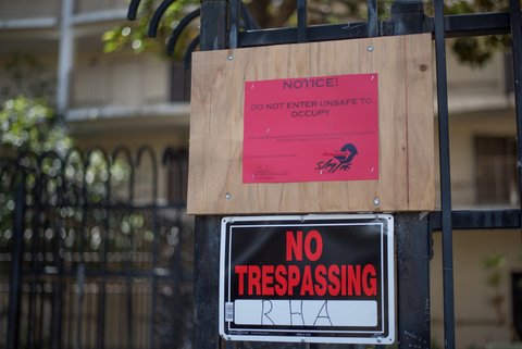 Two signs on a fence. One says "Notice! Do not enter unsafe to occupy." The other says "No trespassing RHA."