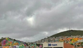 Hills with brightly colored buildings and gray clouds overhead