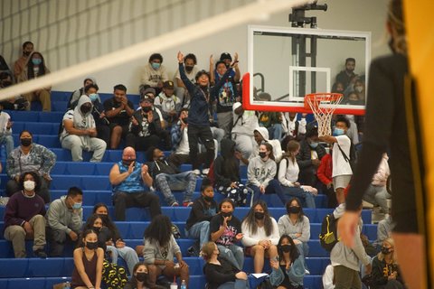 Fans at a game inside a high school gym