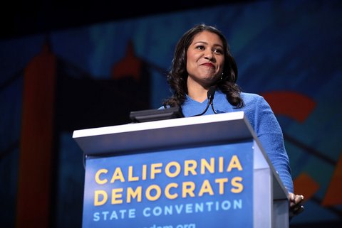 A smiling Black woman in blue at a lectern that says "California Democrats State Convention”