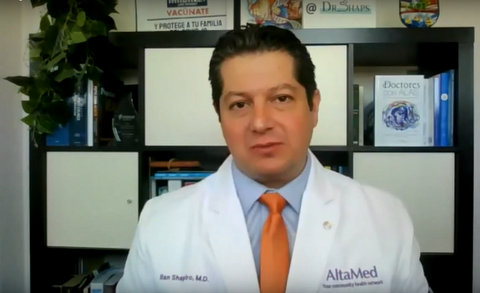 Latino doctor wearing white lab coat and orange tie