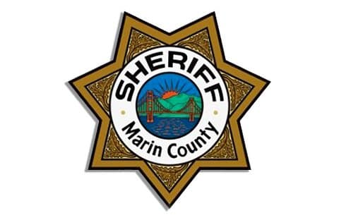 Logo of the Marin County Sheriff's Department, with an illustration of the Golden Gate Bridge, San Francisco Bay and sun behind hills and the words sheriff marin county on a badge symbol