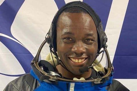 A smiling Black man in astronaut gear