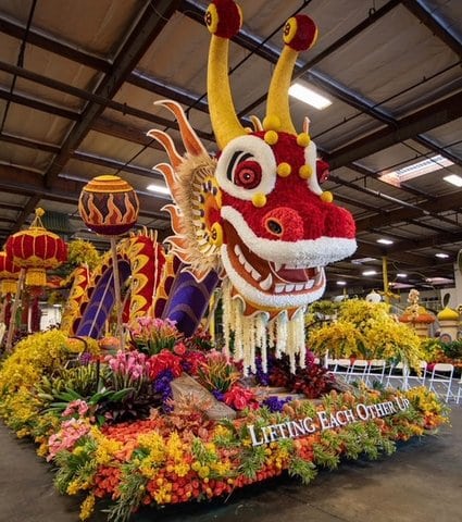 Rose Parade float featuring a red Chinese-style dragon and the words "lifting each other up"