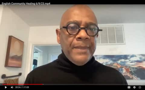 A bald Black man wearing round glasses and black turtleneck sweater