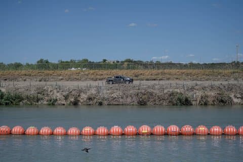 A stretch of large orange buoys with metal rings across the Rio Grande between the U.S. and Mexico