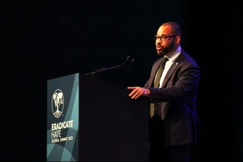 A Black man in a suit at a lectern that says Eradicate Hate Global Summit 2023.