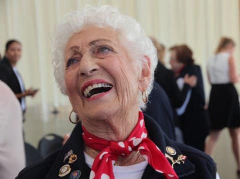 An older white woman with white hair, laughing