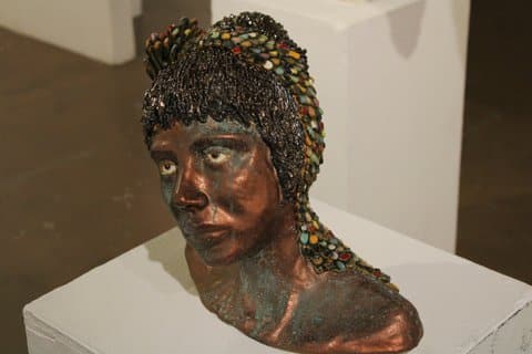 Artwork: a coppery bust adorned with colorful beads