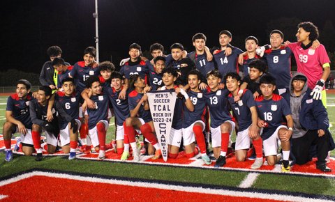 HIgh school boys soccer team posing for on-field team photo with a pennant flag banner that reads men's soccer t-cal rock div 2023-24 champions