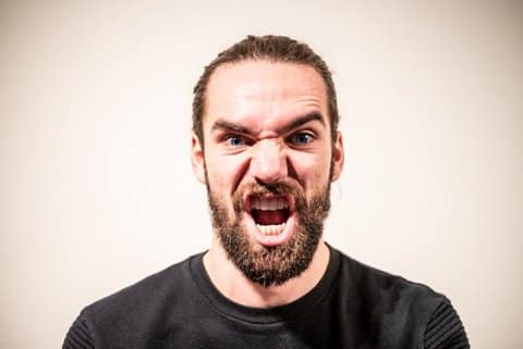 An angry-looking bearded white man yelling