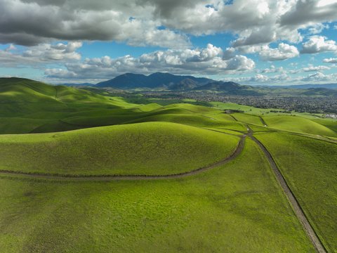 Rolling green hills under a blue sky with fluffy clouds