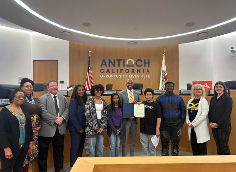 A row of adults and teens standing in antioch city council chambers
