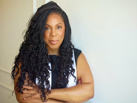 a black woman with long hair and arms crossed