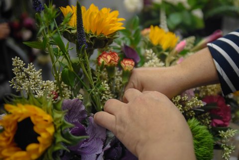 closeup of hands in a bouquet of flowers