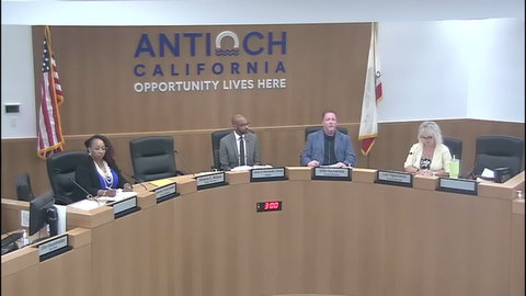 a black woman, black man, white man and white woman, US flag, signage that says antioch california opportunity lives here