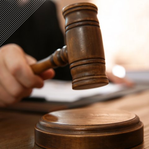 a gavel about to be struck. the hand holding it is visible but out of focus