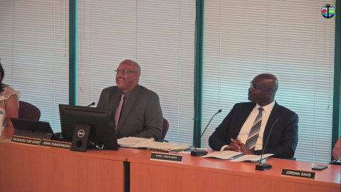 two black men in suits at government meeting