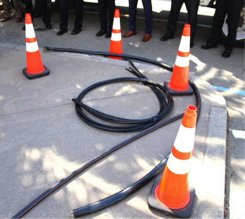 four orange cones set up around thick black cables