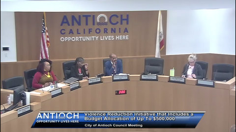 government meeting with two black women, black man, white woman. text: violence reduction initiative that includes a budget allocation of up to $500,000 city of antioch council meeting