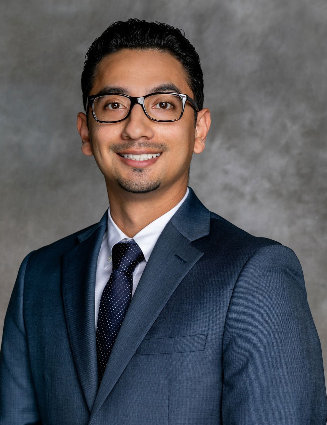 young latino man in suit, tie and glasses