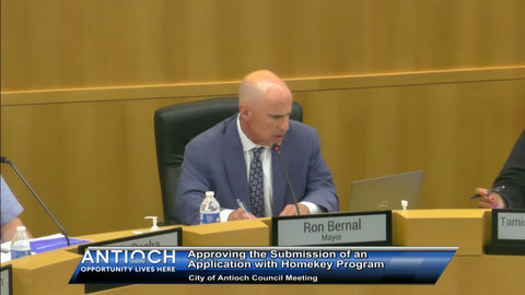 bald man in suit. ron bernal mayor. antioch opportunity lives here. approving the submission of an application with homekey program. city of antioch council meeting.