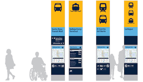 4 examples of new bay area public transit wayfinding signs. each has emblems of the types of transit found there, followed by the name of the station and other information such as a map of nearby buses or times of the next ferries