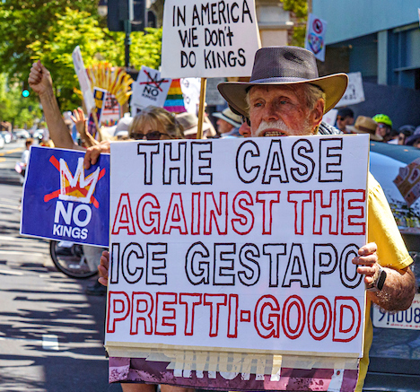 an older white man with white mustache holds a sign that reads the case against the ice gestapo pretti good. other signs in the crowd behind him say no kings and in america we don't do kings