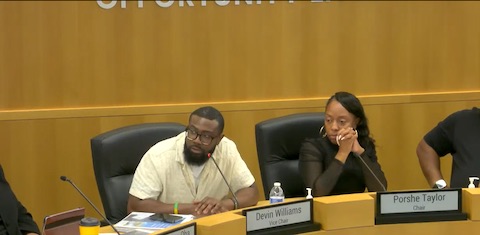 a black man and black woman as public officials in government meeting